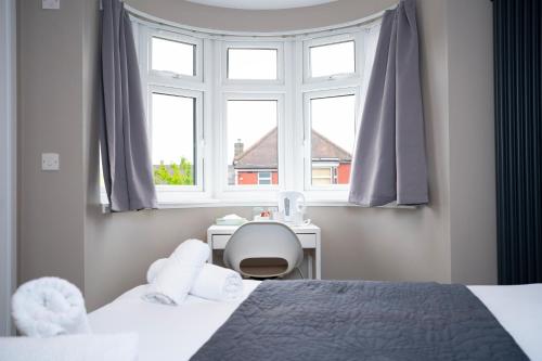 ein Schlafzimmer mit zwei Betten, einem Schreibtisch und einem Fenster in der Unterkunft Rest Inn Edmonton in Edmonton