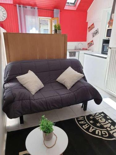 a couch in a living room with a table at Studio gare et commerces sur place in Nogent-lʼArtaud