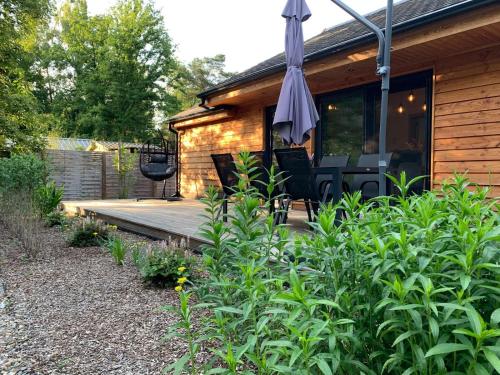 a wooden deck with an umbrella in front of a house at Chalet Liquidambar in Zutendaal