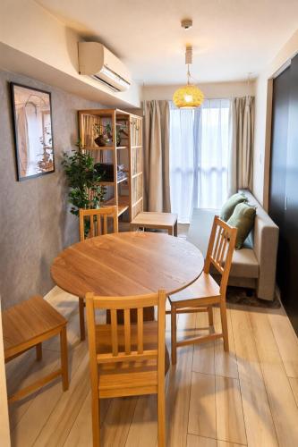 a living room with a wooden table and chairs at Karawaru Stay 亀有 A102 in Tokyo