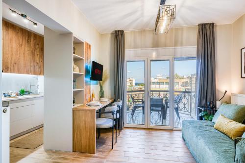 a living room with a couch and a table and a balcony at Modern City Studio with Balcony Columbus Apartment in Chios