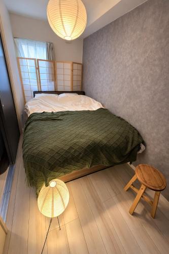 a bedroom with a large bed and a wooden floor at Karawaru Stay 亀有 A102 in Tokyo