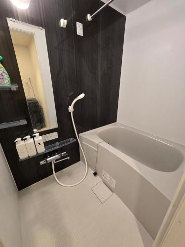 a bathroom with a bath tub and a sink at Karawaru Stay 亀有 A102 in Tokyo