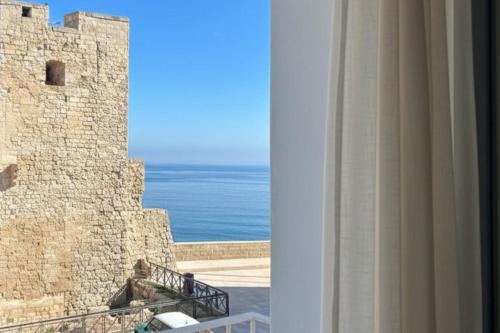 a view of the ocean from a balcony of a castle at Seafront Apartments in Monopoli Old Town in Monopoli