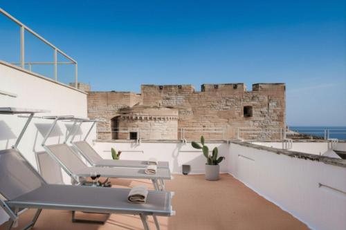 a balcony with chairs and a view of the ocean at Seafront Apartments in Monopoli Old Town in Monopoli