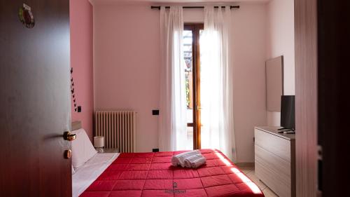 a bedroom with a red bed and a window at I Portici - Cernobbio in Cernobbio