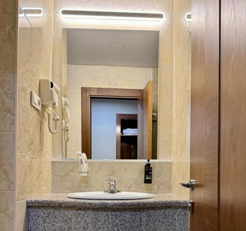 a bathroom with a sink and a mirror at Grand Hotel Eurasia in Almaty