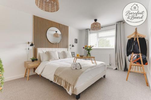 a bedroom with a large bed and a mirror at Luxury 2-Bed House in Stevenage Sleeps 6 Free Parking Barefoot & Board in Shephall