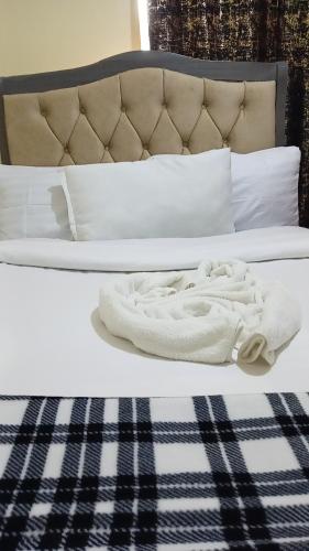 a bed with two white towels on top of it at KiQao in Nakuru