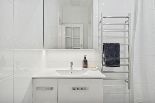 a white bathroom with a sink and a mirror at Beach House Family Friendly Enclosed Yard in Rockingham
