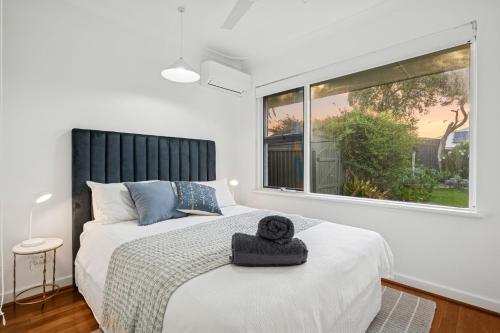 a bedroom with a bed and a large window at Beach House Family Friendly Enclosed Yard in Rockingham