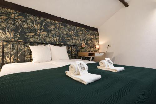 a hotel room with a bed with towels on it at King's Inn City Hostel Alkmaar in Alkmaar