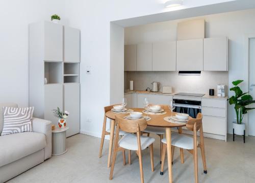 a kitchen and living room with a wooden table and chairs at Erbusco Charme Apartment in Erbusco