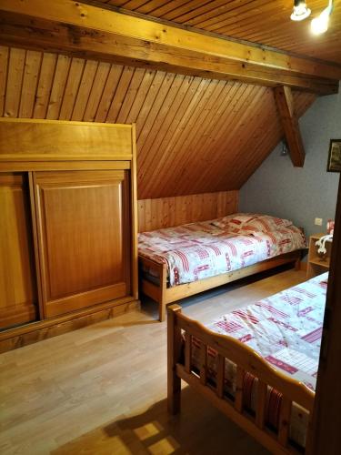 two beds in a room with wooden ceilings at Chalet La Grange de Madi in Muhlbach-sur-Munster