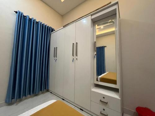 a bathroom with white cabinets and a mirror at Chaithanya Residency Near to IIM & NIT Kozhikode in Kunnamangalam