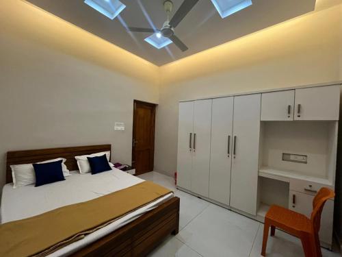 a bedroom with a bed and a ceiling fan at Chaithanya Residency Near to IIM & NIT Kozhikode in Kunnamangalam