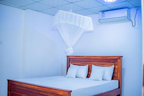 a bedroom with a wooden bed with white pillows at Tourist Holiday Inn in Dambulla