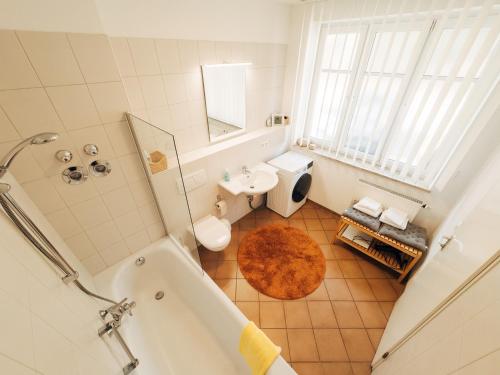 a bathroom with a tub and a toilet and a sink at Ferienwohnung Ammersee in Andechs