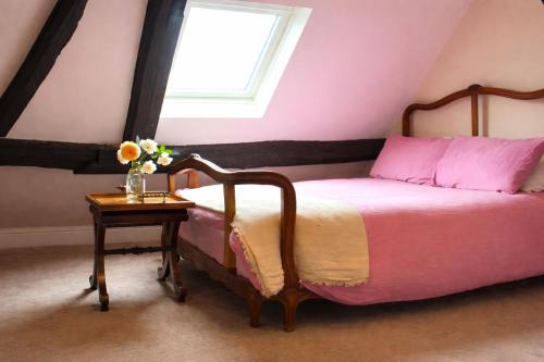 a bedroom with a bed and a table with a vase of flowers at The Corner House, Shipston-on-Stour in Shipston-on-Stour