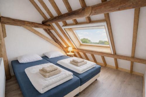 two beds in a room with a window at Ballumerhoeve Finn lodge in Ballum