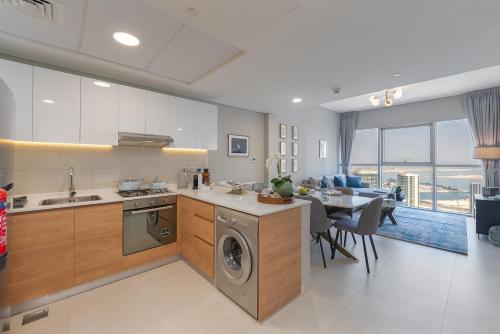 a kitchen with a dishwasher and a table and a dining room at Urban Chic - Radiant in Abu Dhabi