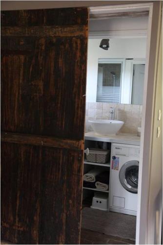 une salle de bain avec un lavabo et une machine à laver dans l'établissement L'Etable d'Emile, à Marais-Vernier