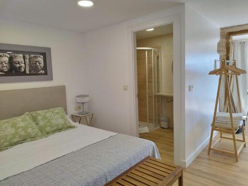 a bedroom with a bed and a wooden chair at Alojamientos as moras arans in La Cañiza