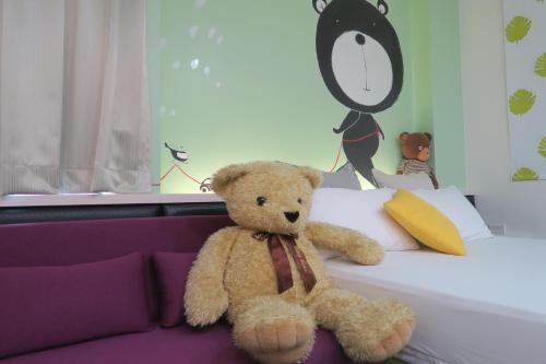 a teddy bear sitting on top of a bed at ChaoPingJia Fengge Guesthouse in Wujie