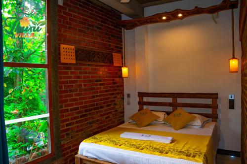 a bed in a room with a brick wall at Thuru Airport Apartment in Seeduwa
