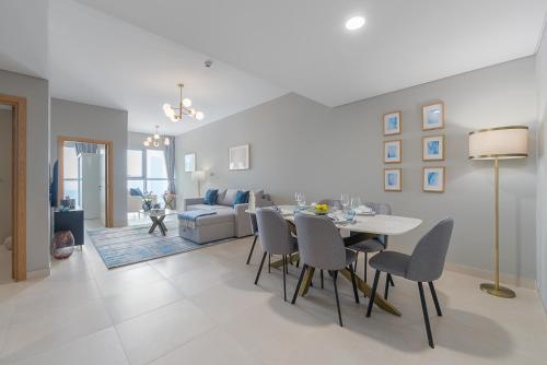 a dining room and living room with a table and chairs at Urban Chic - Radiant in Abu Dhabi