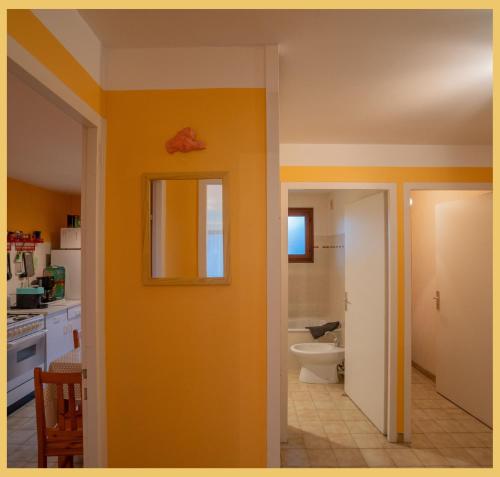 a bathroom with a toilet and a yellow wall at L'appartement des Cimes I Doussard in Doussard