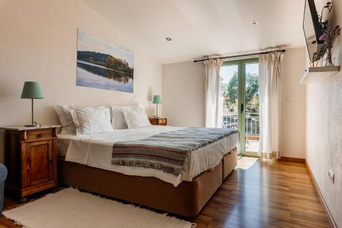 a bedroom with a large bed and a large window at Vale De Ferreiros in Abrantes