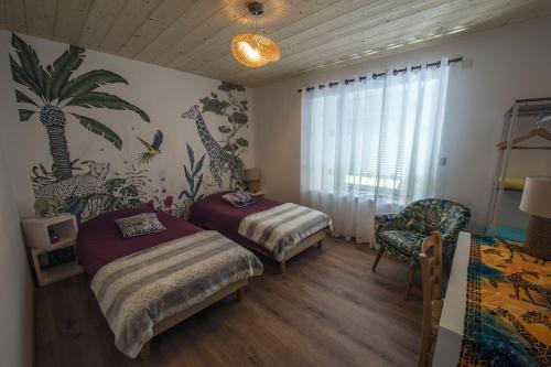 a bedroom with two beds and a chair and a window at LE NID DES PLANCHETTES - Suite Chambres d'Hôtes in Germéfontaine