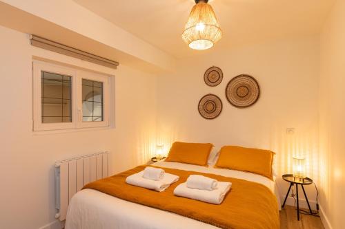 a bedroom with a bed with two towels on it at Zest Vendome - Saxe Gambetta in Lyon