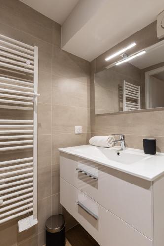 a bathroom with a white sink and a mirror at Zest Vendome - Saxe Gambetta in Lyon