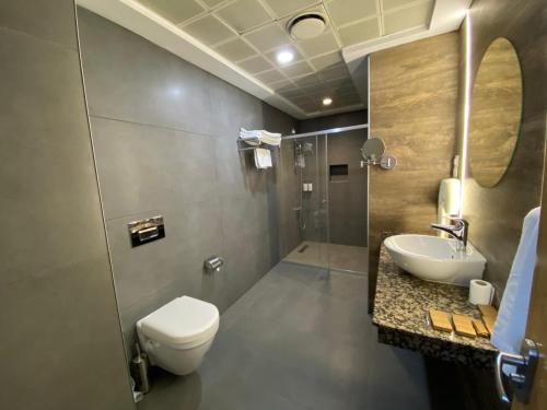 a bathroom with a toilet and a sink and a shower at Gaziantep Plaza Hotel in Gaziantep