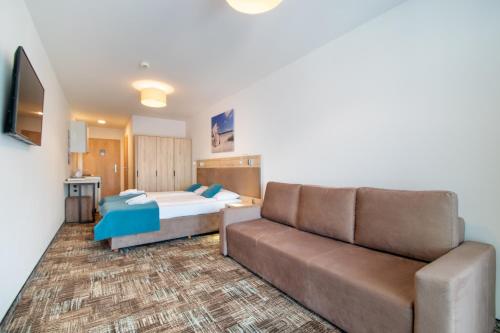 a living room with a couch and a bed at RentPlanet - Welle Resort in Grzybowo