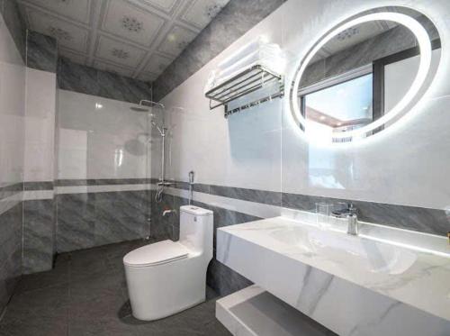 a bathroom with a toilet and a sink and a mirror at Phố Cổ Legend Hotel in Phúc Lộc