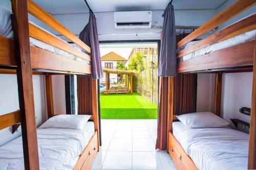 two bunk beds in a room with a yard at What The Duck Backpackers in Canggu