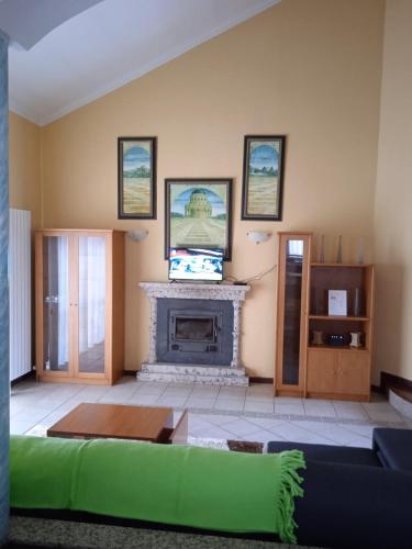 a living room with a fireplace and a green couch at Casa Travessa da Quinta in Mondim de Basto