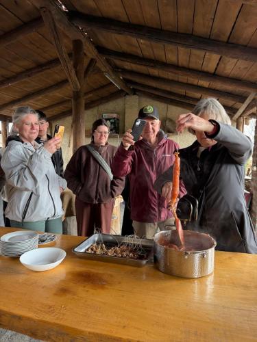 a group of people taking pictures of a table with food at Gugoshvili's Cellar in Kvareli