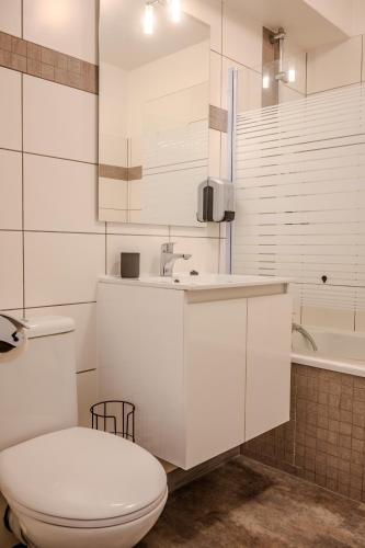 a bathroom with a toilet and a sink and a tub at Ma Préférence - Studio Cozy - Parking Gratuit - Proche Commerces & Transports in Horbourg