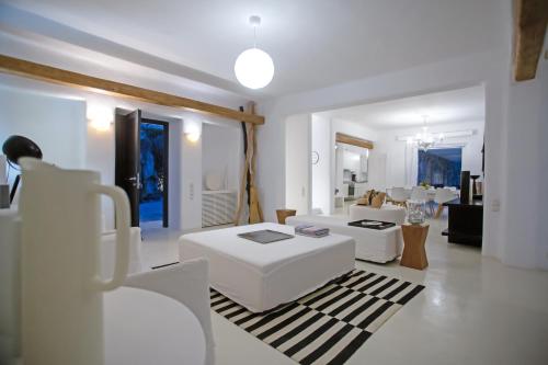 a white living room with white tables and chairs at Maison Haute Mykonos in Ornos