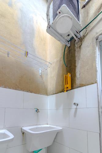 a bathroom with two sinks and a light on the wall at Quartos privativos - São Domingos, Niterói in Niterói