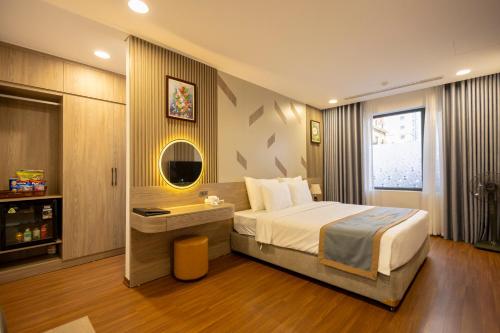 a hotel room with a bed and a mirror at Mai Lakeside Hotel Ninh Binh in Kỳ Vĩ