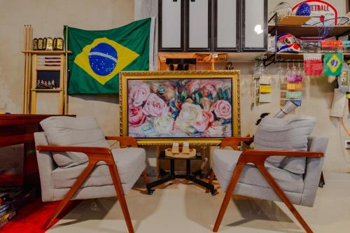 a room with two chairs and a flag on the wall at Quartos privativos - São Domingos, Niterói in Niterói