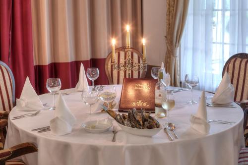 a table with a white table cloth and wine glasses at Dworek Hetmanski in Stargard