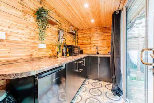 a kitchen with wooden walls and a counter top at Cadnam Cottage with Private Hot Tub, New Forest in Cadnam