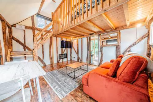 a living room with a red couch and a table at Cadnam Cottage with Private Hot Tub, New Forest in Cadnam