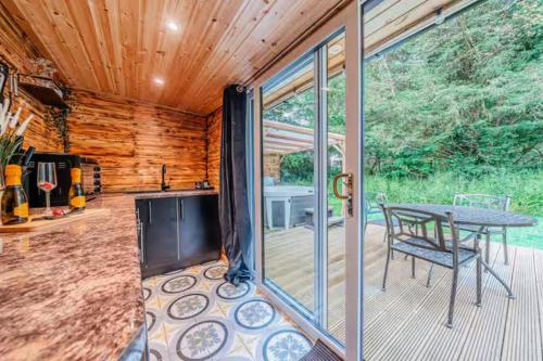 a screened in porch with a table on a deck at Cadnam Cottage with Private Hot Tub, New Forest in Cadnam